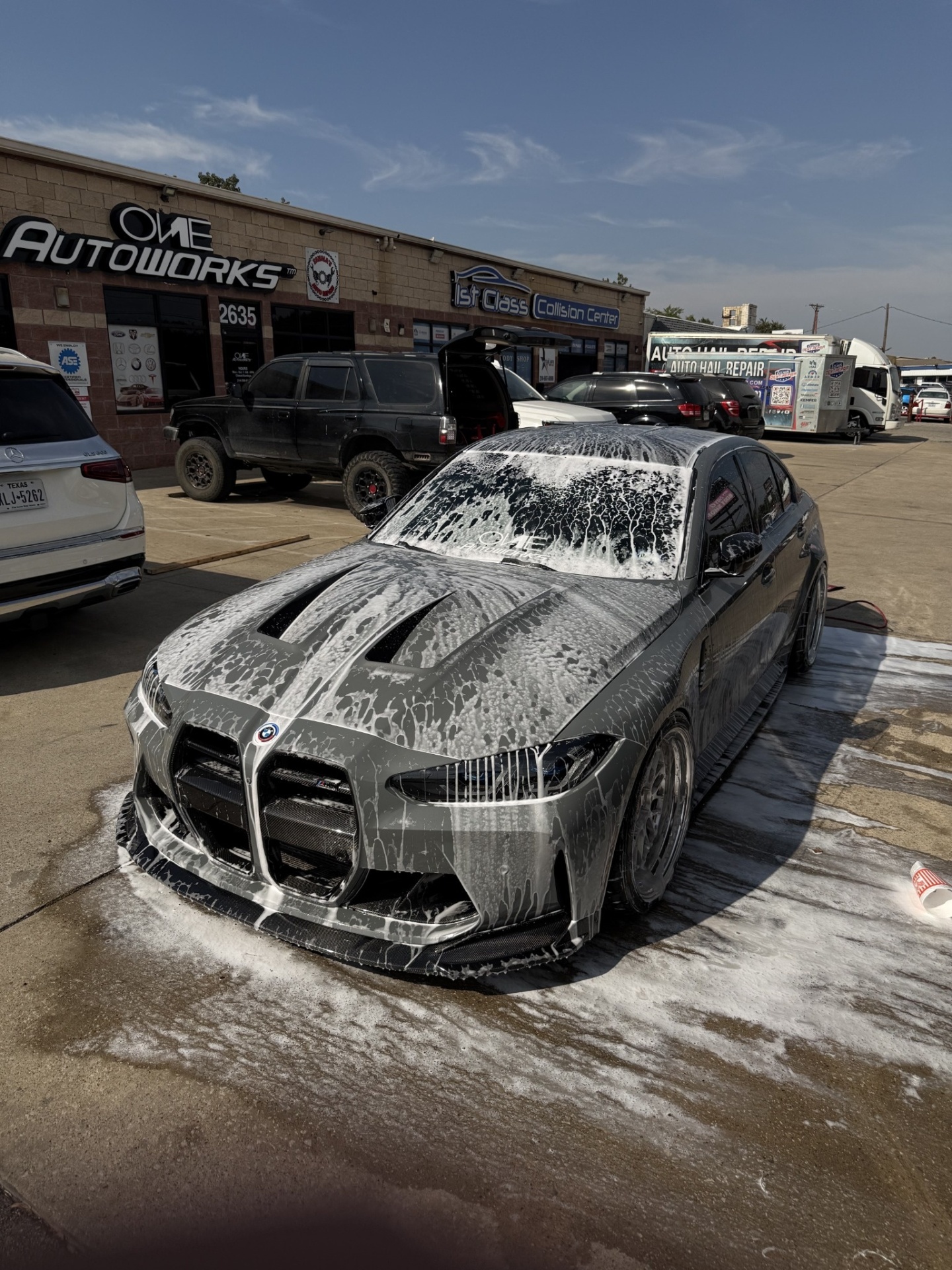 Gray BMW M coupe covered in foam during an exterior wash